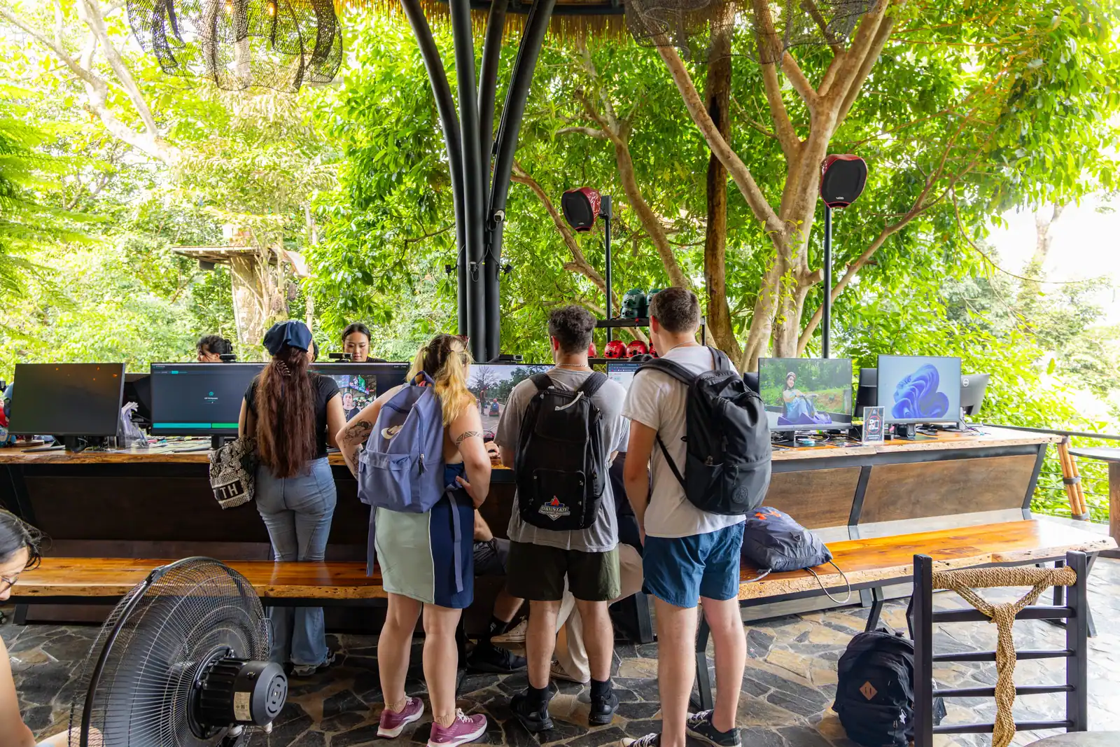 Visitors at a photo-viewing counter beneath a shaded roof at Hanuman Luge.